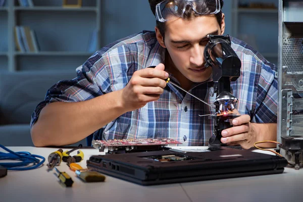 Reparatör försöker reparera bärbar dator med miscroscope — Stockfoto