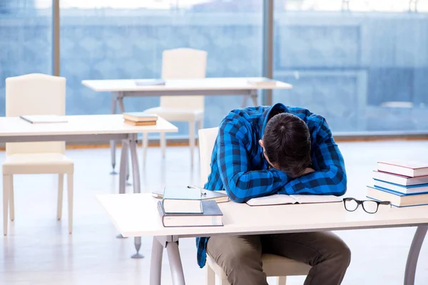 Studente che studia nella biblioteca vuota con libro di preparazione per ex — Foto Stock