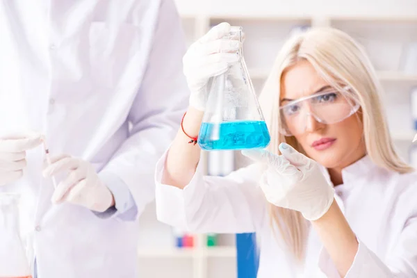 Mujer joven química que trabaja en el laboratorio de la clínica —  Fotos de Stock