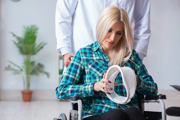 Mujer discapacitada en silla de ruedas visitando al médico hombre —  Fotos de Stock