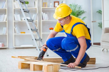 Ahşap palet montajı yapan genç adam.