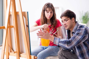 Stüdyoda resim sınıfında sanatçı koçluğu yapan bir öğrenci.