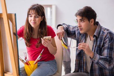 Stüdyoda resim sınıfında sanatçı koçluğu yapan bir öğrenci.