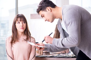 Güzellik salonunda güzel bir kadın için makyaj yapan adam.