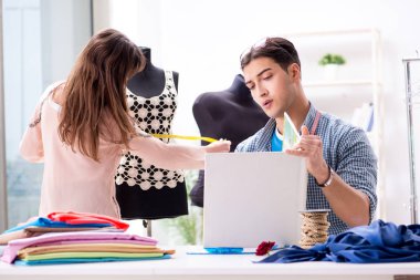 Atölyede erkek terzi ve bayan öğrenci.