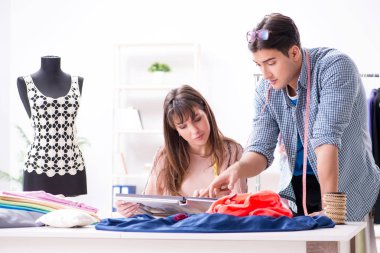 Atölyede erkek terzi ve bayan öğrenci.