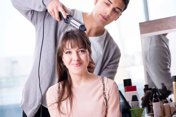 Man stylist working with woman in beauty salon