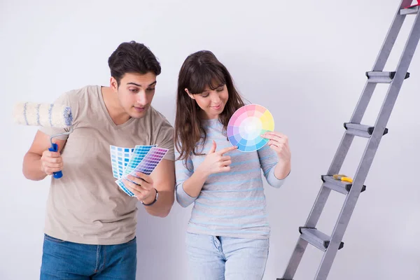 Молодая семья делает ремонт в доме - покраска стен — стоковое фото