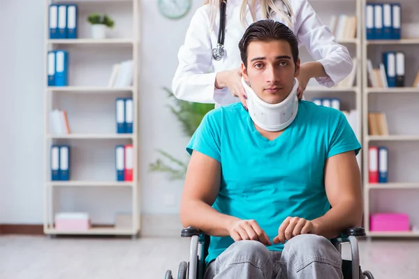 Hombre discapacitado en silla de ruedas visitando a una doctora —  Fotos de Stock