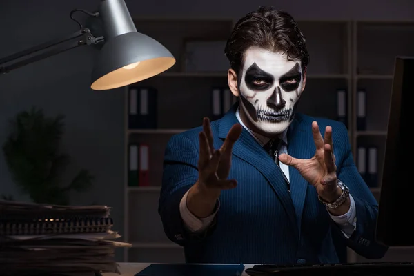 Businessman with scary face mask working late in office — Stock Photo, Image