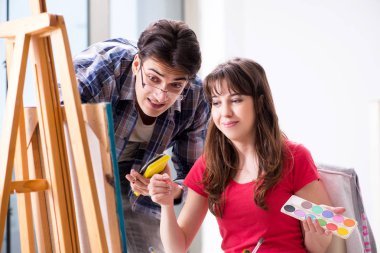 Stüdyoda resim sınıfında sanatçı koçluğu yapan bir öğrenci.