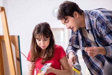 Stüdyoda resim sınıfında sanatçı koçluğu yapan bir öğrenci.