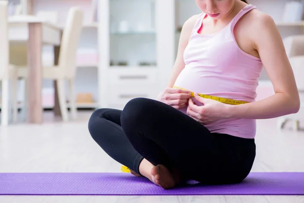 Kobieta w ciąży ćwicząca w oczekiwaniu na poród dziecka — Zdjęcie stockowe