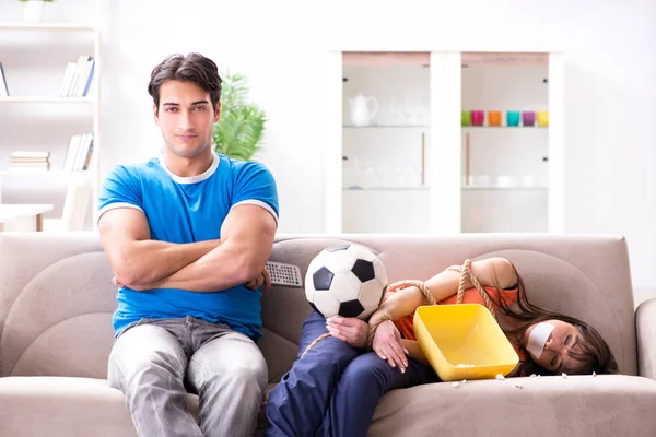 Uomo legando sua moglie per guardare il calcio sportivo — Foto Stock