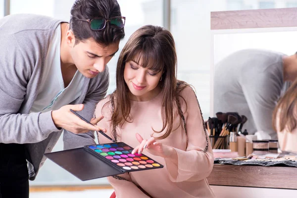 Man doing make-up for cute woman in beauty salon — Stock Photo, Image