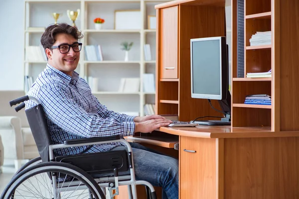 Gehandicapte student die thuis in een rolstoel studeert — Stockfoto