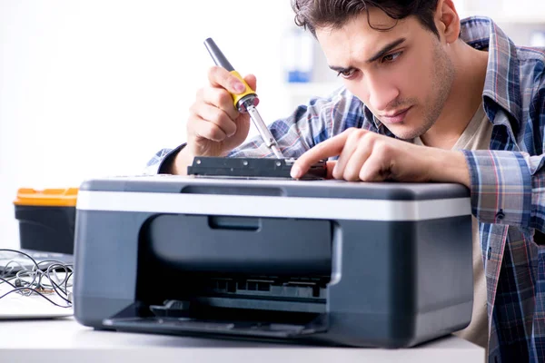 Ремонтник оборудования ремонтирует сломанный факс принтера — стоковое фото