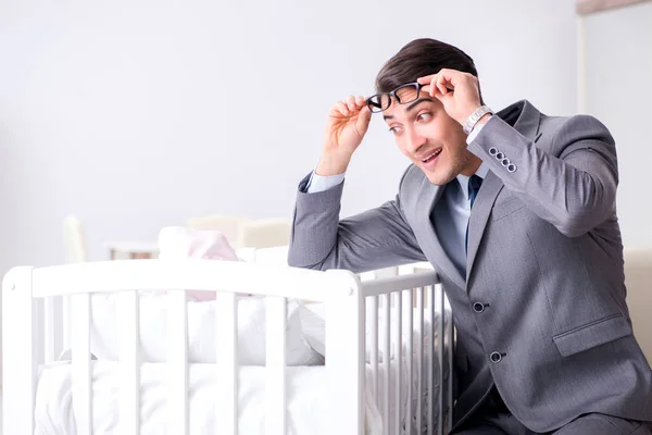 Joven hombre de negocios tratando de trabajar desde casa cuidando después del recién nacido —  Fotos de Stock
