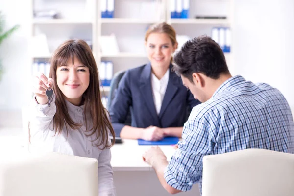 Young family agreeing mortgage contract in the bank for new hous — Stock Photo, Image