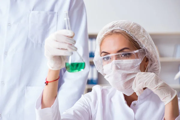 Ung kvinde kemiker arbejder i klinik lab - Stock-foto