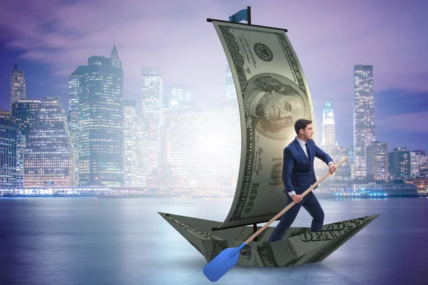 Empresario remando en barco dólar en concepto financiero de negocios — Foto de Stock