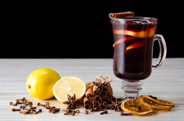 Haşlanmış şarap, yılbaşı masasında servis edilen bardaklarda parlıyor.