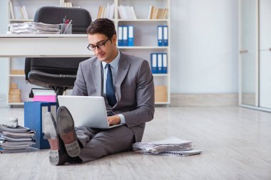 İş adamı ofiste çalışıyor ve oturuyor.