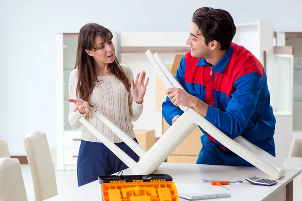 Aannemer reparateur monteert meubels onder toezicht van een vrouw — Stockfoto