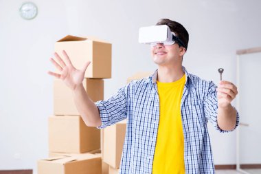 VR gözlüklü genç adam yeni daireye taşınıyor.