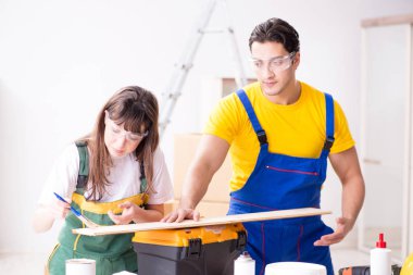 Ahşap atölyesinde kadın marangozluk ipuçlarını açıklayan adam