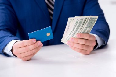 Dolar ve kredi kartı elinde tutan bir işadamı.