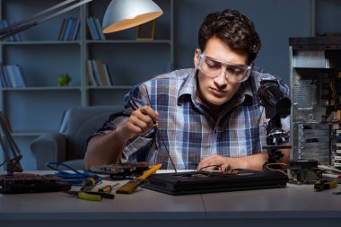Genç tamirci ana yaban domuzunun elektrik parçalarını lehimliyor.