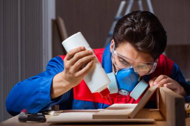 Genç adam ahşap parçaları DIY konseptinde yapıştırıyor.