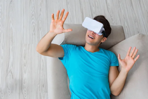 Jongeman met VR-bril ontspannen op de bank — Stockfoto