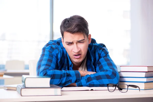 Studente che studia nella biblioteca vuota con libro di preparazione per ex — Foto Stock