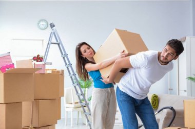 Yeni evdeki kutuları açan genç bir aile.