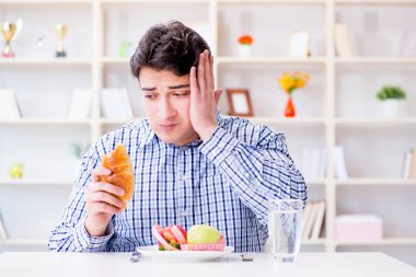 Man having dilemma between healthy food and bread in dieting con clipart