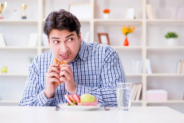 Diyet dolandırıcılığında sağlıklı yemek ve ekmek arasında ikilem yaşayan bir adam.