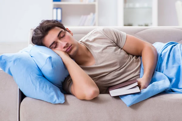 Young student man preparing for college exams in bed with book — Stock Photo, Image