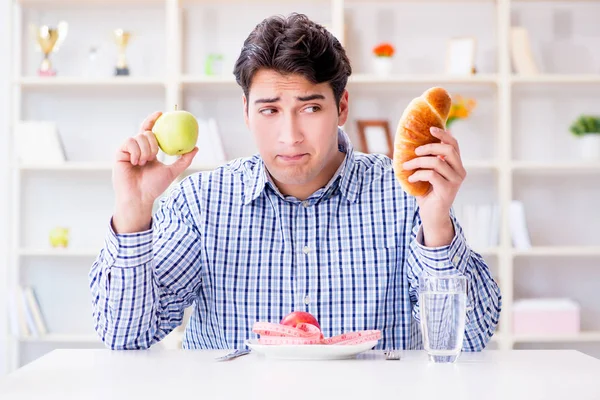 Ο άνθρωπος που έχει δίλημμα μεταξύ υγιεινής διατροφής και ψωμιού σε δίαιτα — Φωτογραφία Αρχείου