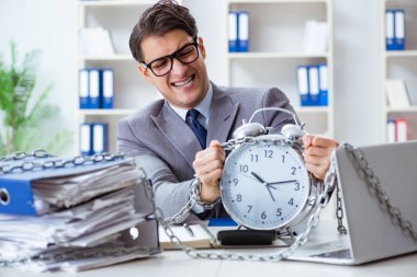 Ofis masasına zincirlenmiş meşgul bir çalışan.