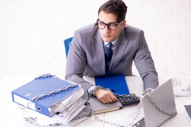 Ofis masasına zincirlenmiş meşgul bir çalışan.