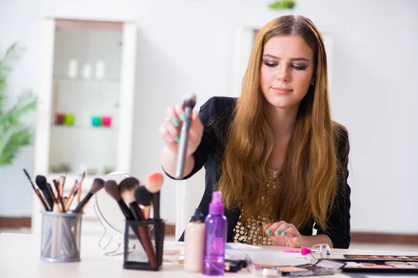 Mujer joven aplicando maquillaje preparándose para la fiesta — Foto de Stock