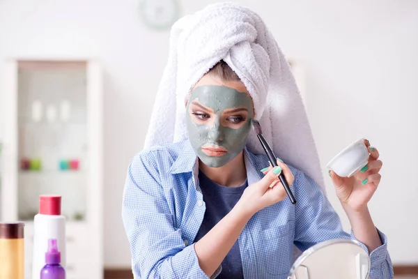 Kvinna tillämpa lera mask med borste hemma — Stockfoto