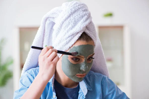 Mujer aplicando mascarilla de barro con cepillo en casa — Foto de Stock