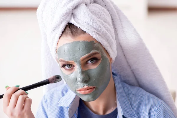 Mujer aplicando mascarilla de barro con cepillo en casa — Foto de Stock