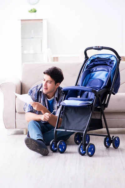 Jovem pai montando carrinho de bebê em casa — Fotografia de Stock
