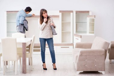 Mağazadaki evli çift mobilya seçiyor.