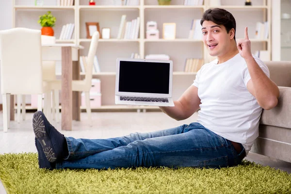 카펫 바닥에 있는 집에서 노트북으로 일하는 사람 — 스톡 사진