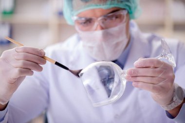 Adli tıp dedektifi suç delilleri üzerinde çalışıyor.
